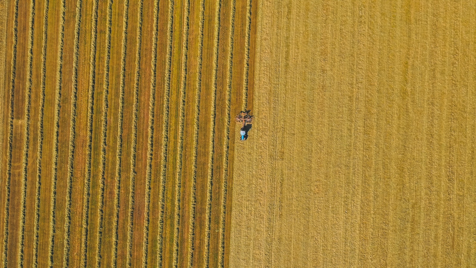 an aerial view of a farmer's field with a tractor in the middle of